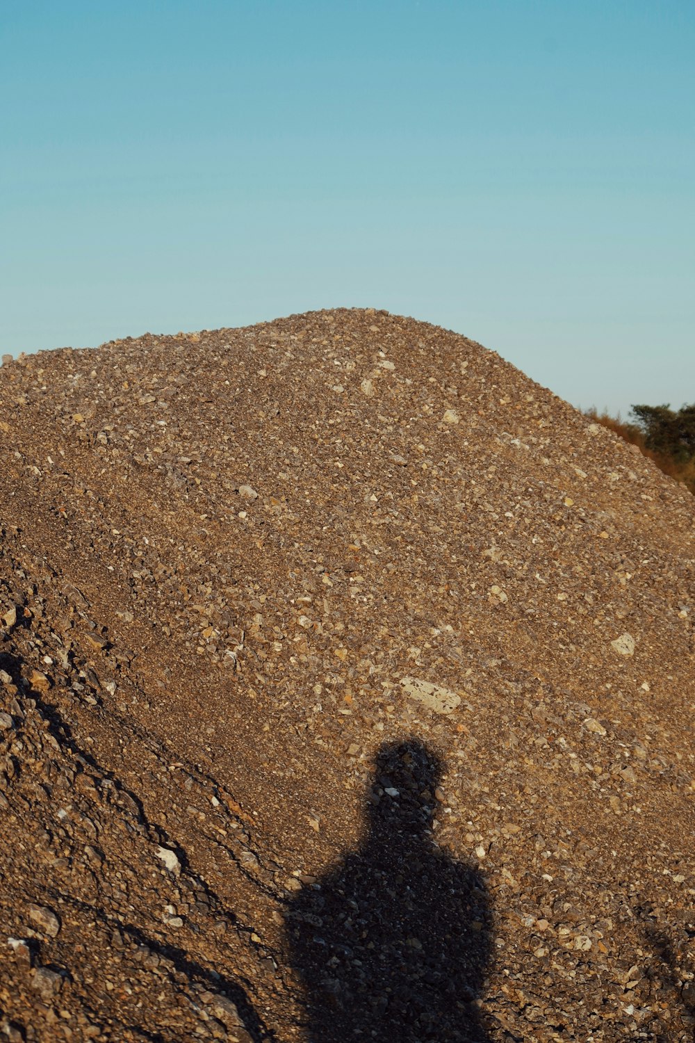 a shadow of a person on a rock