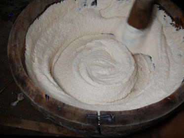 Traditional churn and fresh cream in a village kitchen setting, highlighting authentic preparation.