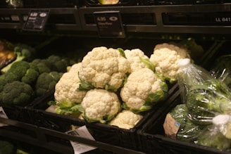 a bunch of cauliflowers in a grocery store