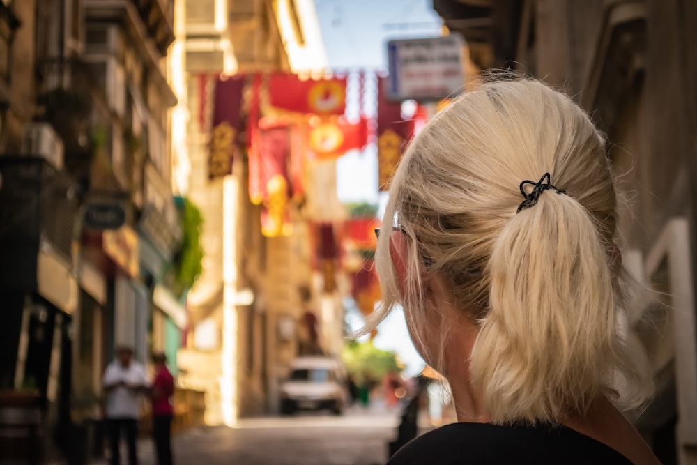 a woman with a ponytail looking down at a street