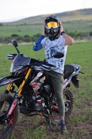 A rider adjusting goggles while sitting on a dirt bike, ready to hit the track