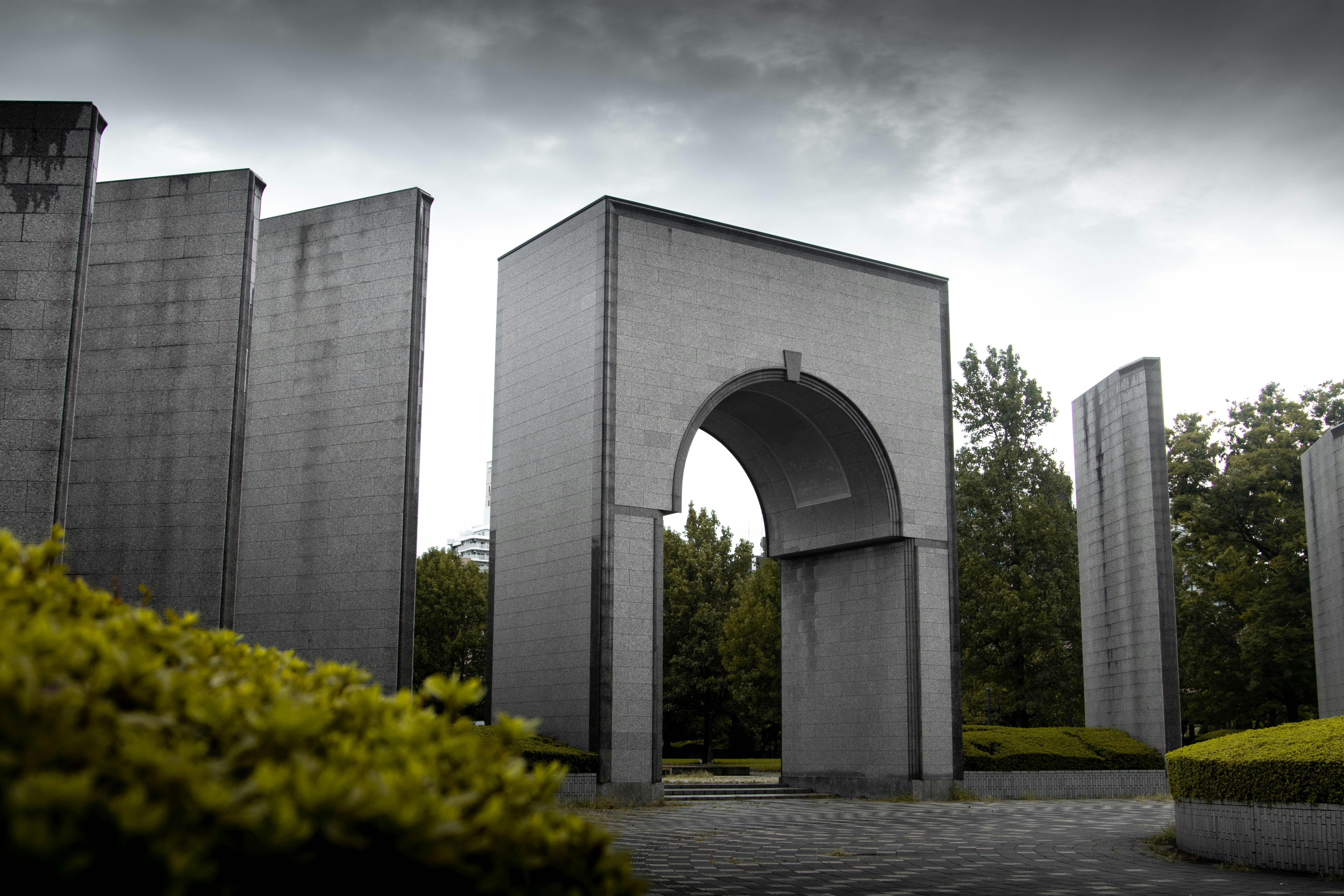 a large stone structure with trees and bushes around it