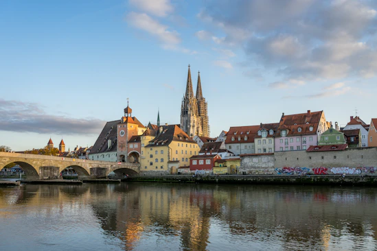 a river with Regensburg and buildings along it