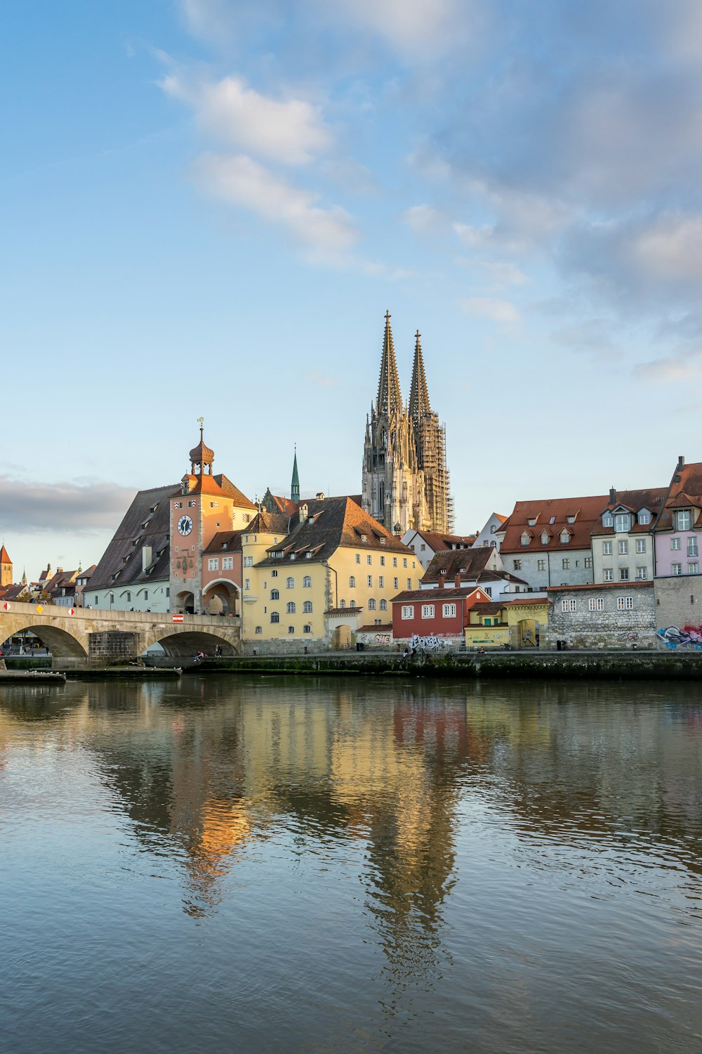 a river with buildings along it with Regensburg in the background