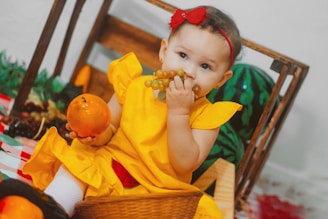 A joyful child holding a basket of fresh fruits surrounded by colorful healthy snacks.