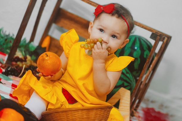 A joyful child holding a basket of fresh fruits surrounded by colorful healthy snacks.