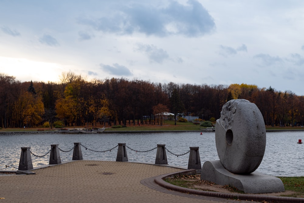 a stone statue next to a body of water