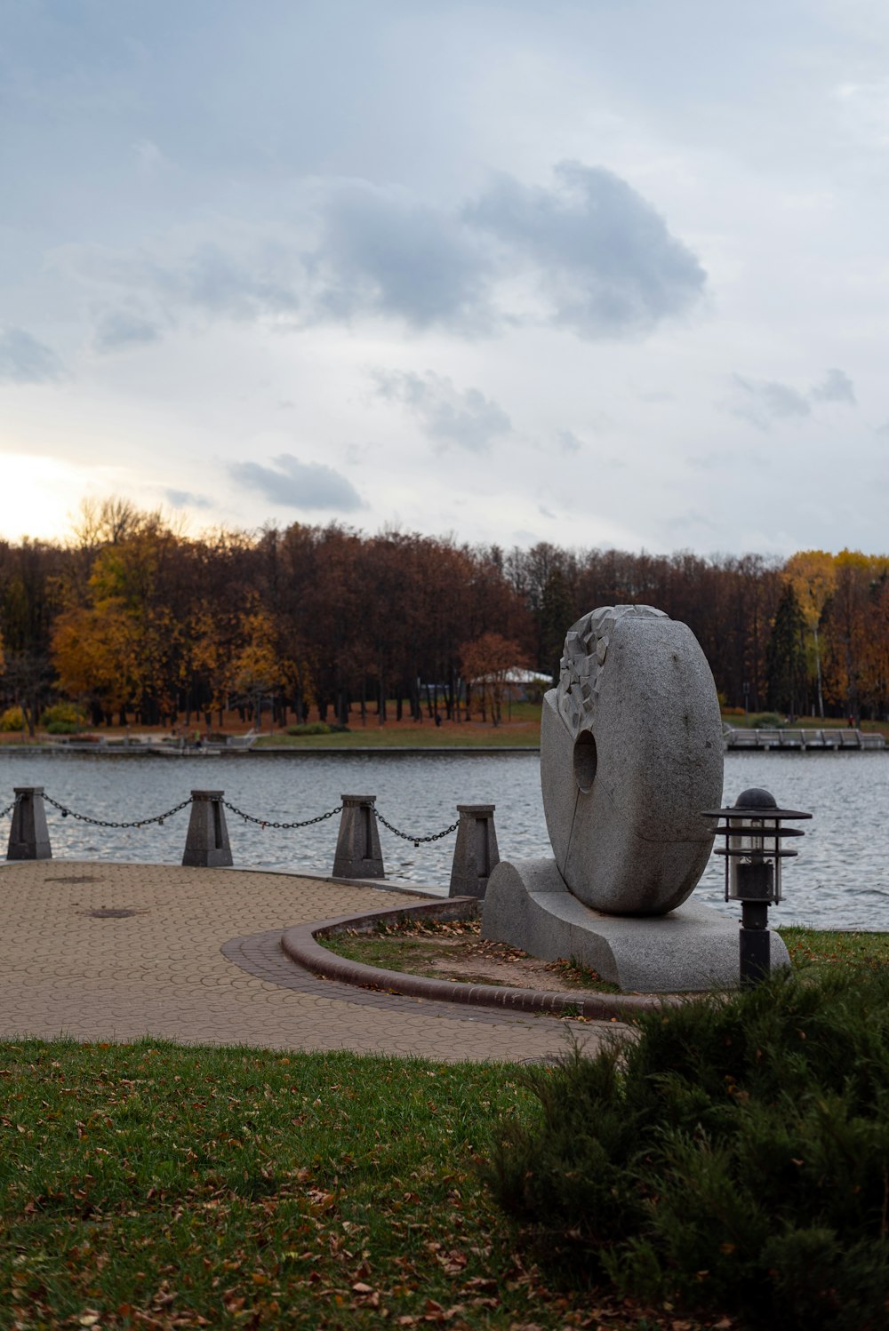 a stone statue by a body of water