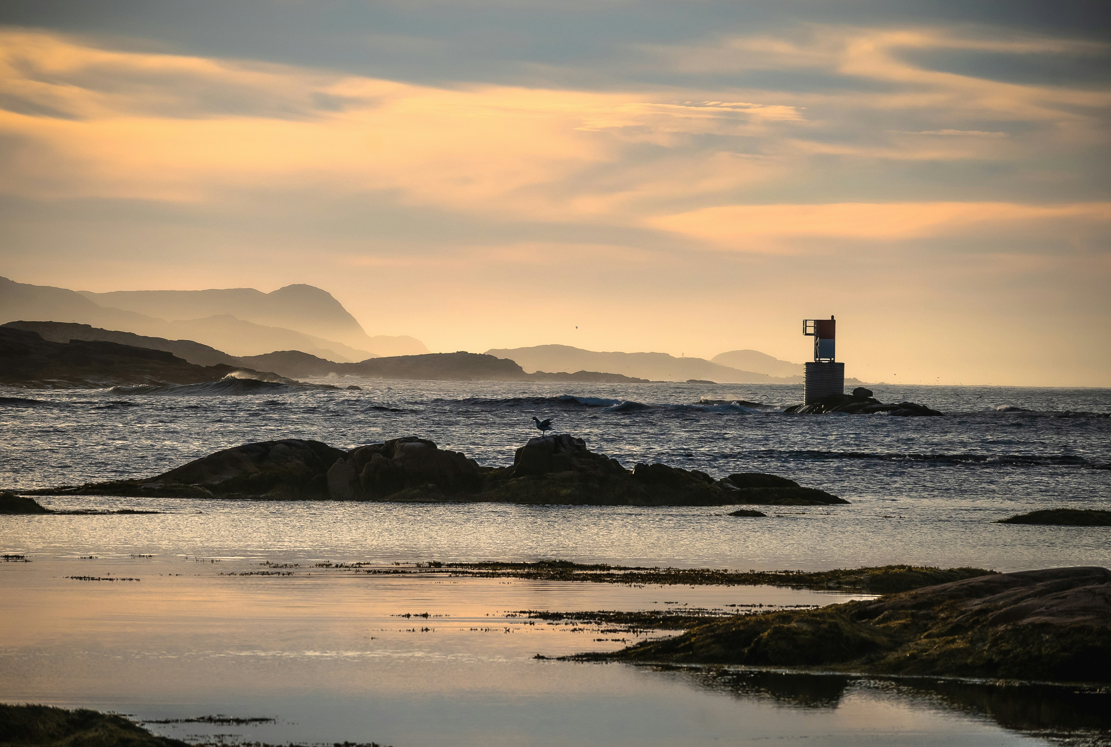 a lighthouse on a rocky beach, 