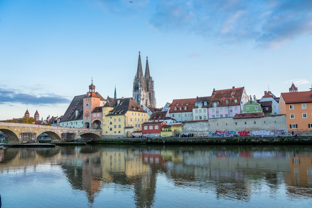 um corpo de água com edifícios ao longo dele com Regensburg ao fundo