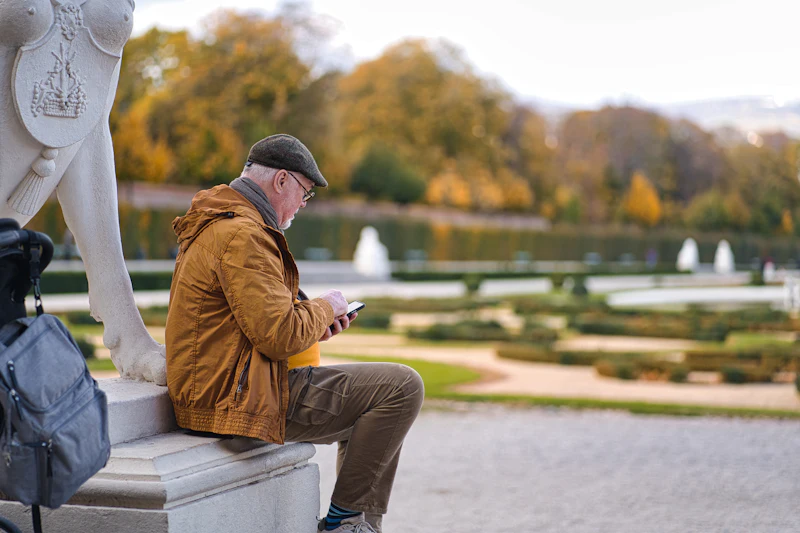 A man sitting on a bench looking at his phone