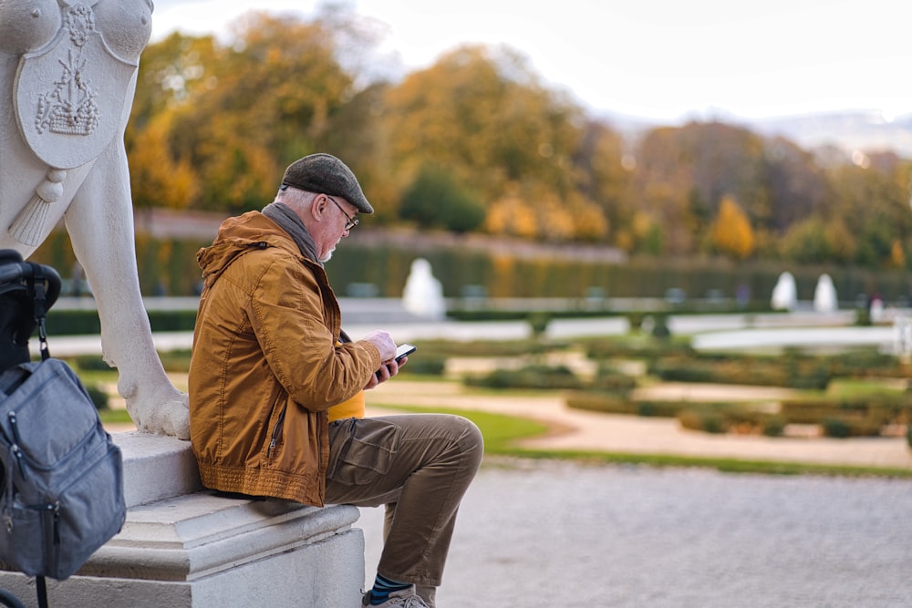 a man sitting on a bench looking at his phone