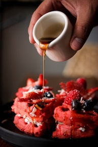 a person pouring a drink into a glass