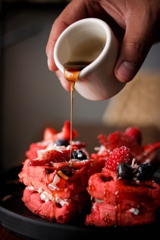a person pouring a drink into a glass