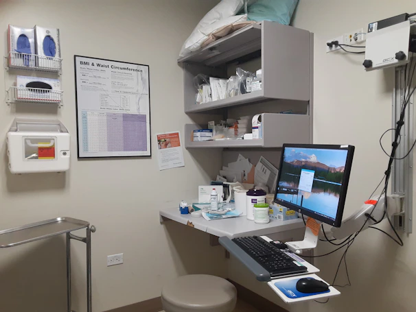 A warm, inviting consultation room with a computer and medical tools ready for patient management.