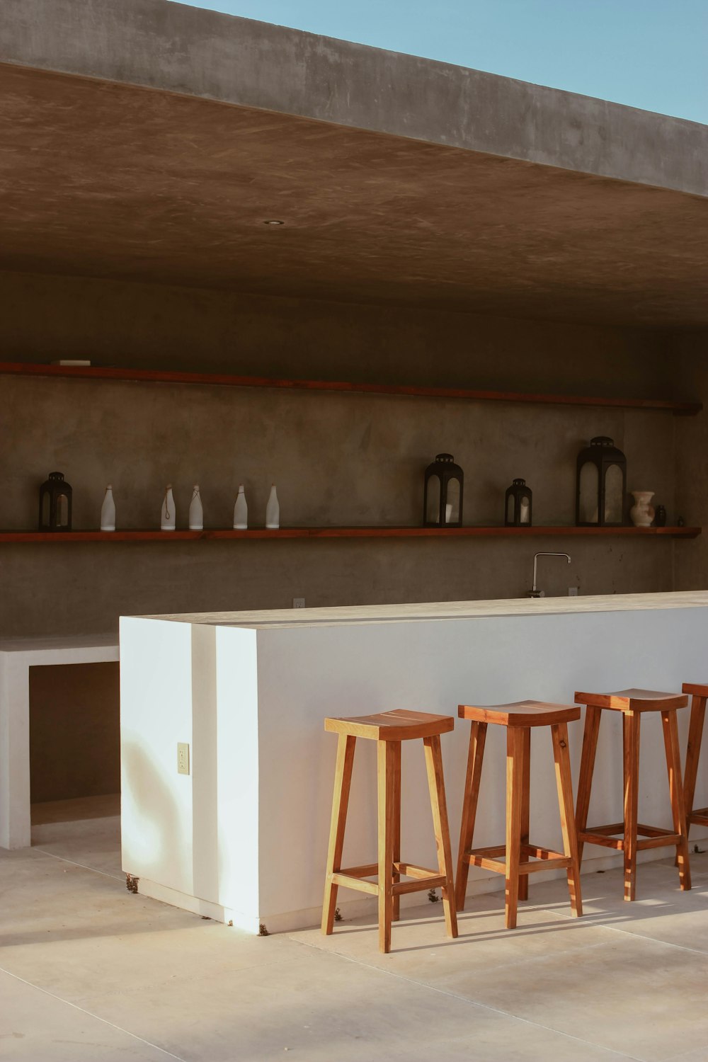 a group of stools in front of a shelf with objects on it