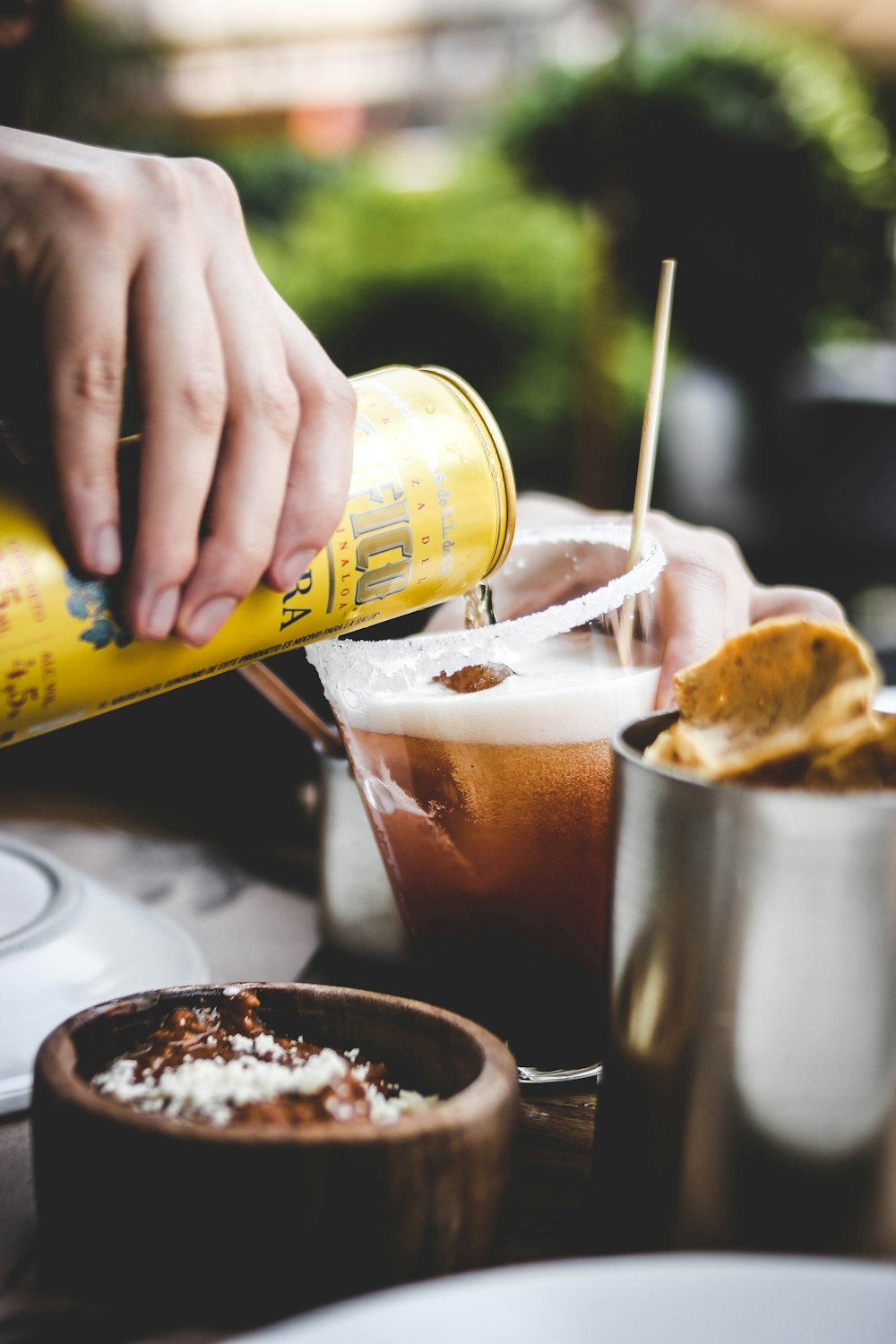 a person pouring a drink into a glass