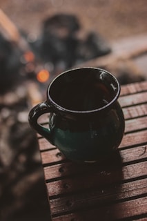 A cozy ceramic mug with a smooth matte finish resting on a wooden table.