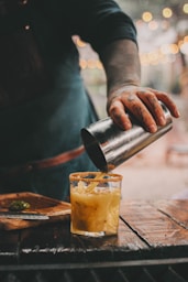 a person cutting a glass of beer
