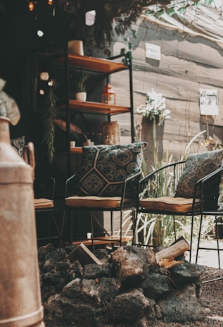 A cozy backyard patio surrounded by well-maintained plants and decorative stones.