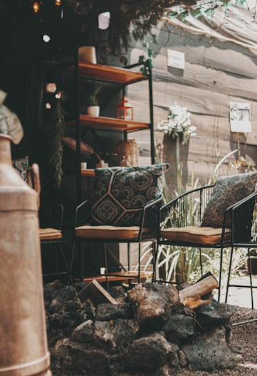 A beautifully crafted stone patio with warm lighting in a cozy backyard setting.