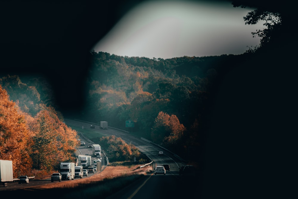 a road with cars on it and trees on the side