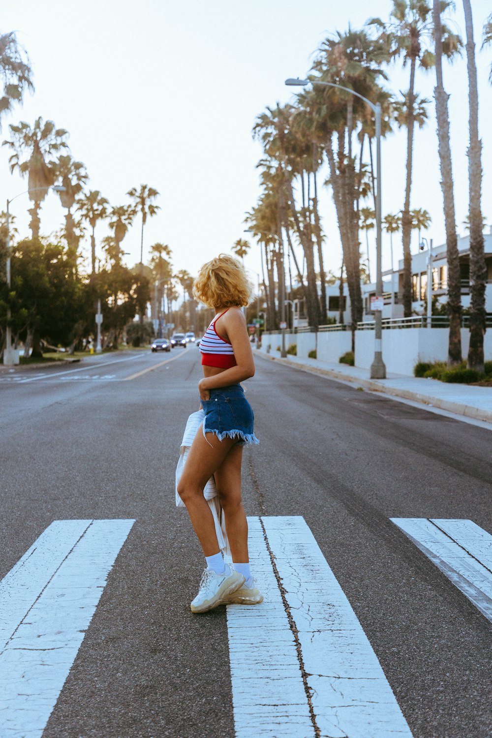 a person in a red and white striped shirt walking on a street