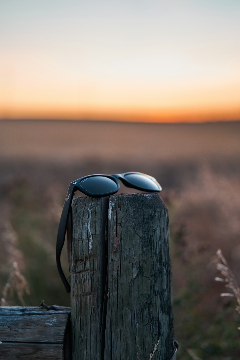 a pair of sunglasses on a wooden post
