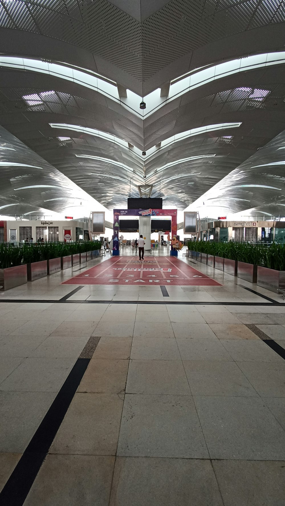 a large building with a walkway and people walking around