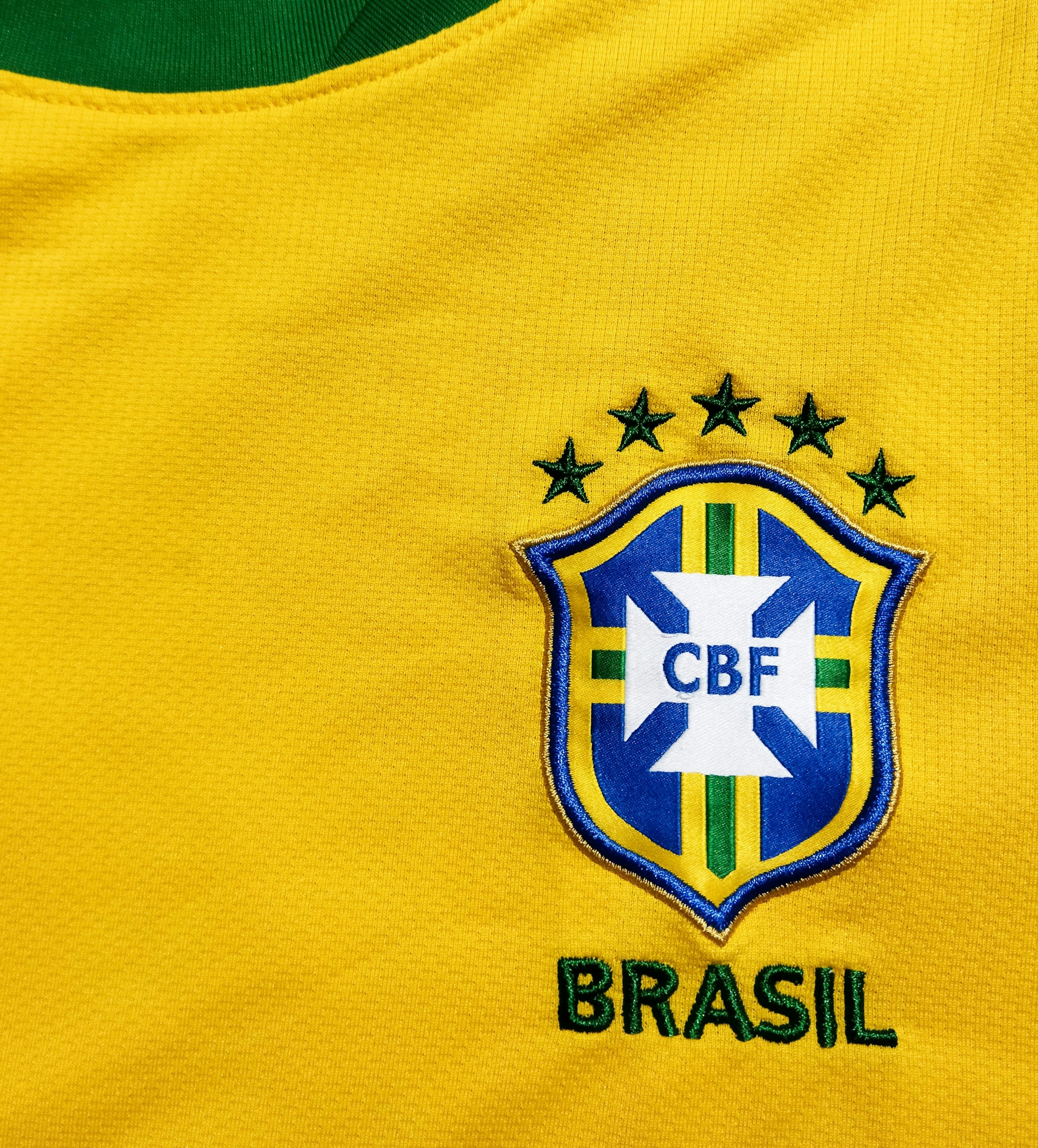 Yellow Brazil vintage football jersey in warm dim display lighting with retro background