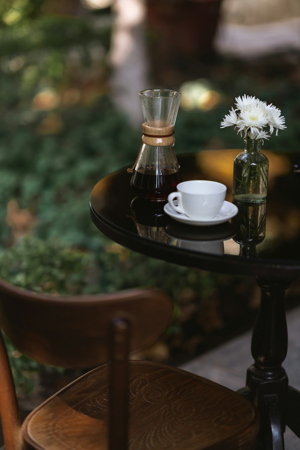 une table avec un vase et une tasse de café dessus