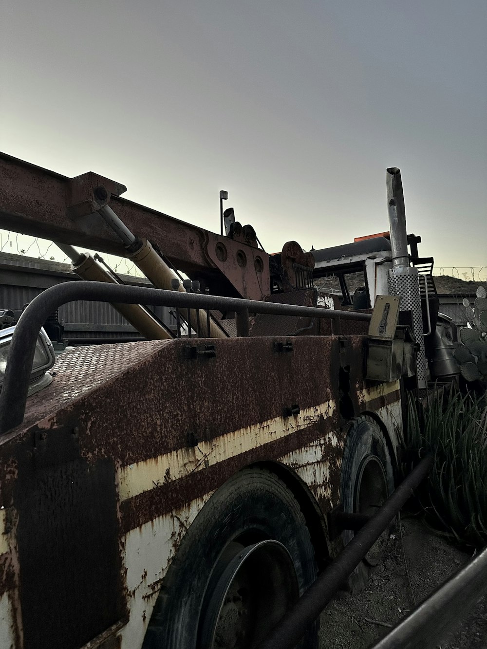 a rusted out truck with a large metal pipe