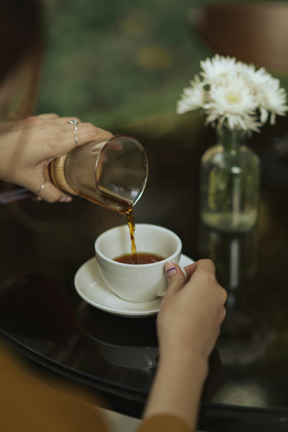 a person pouring a liquid into a cup