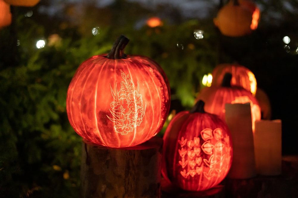 a group of red and orange pumpkins with lights in the background