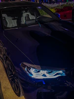 A polished black Mercedes limousine with elegant lighting on a night drive.