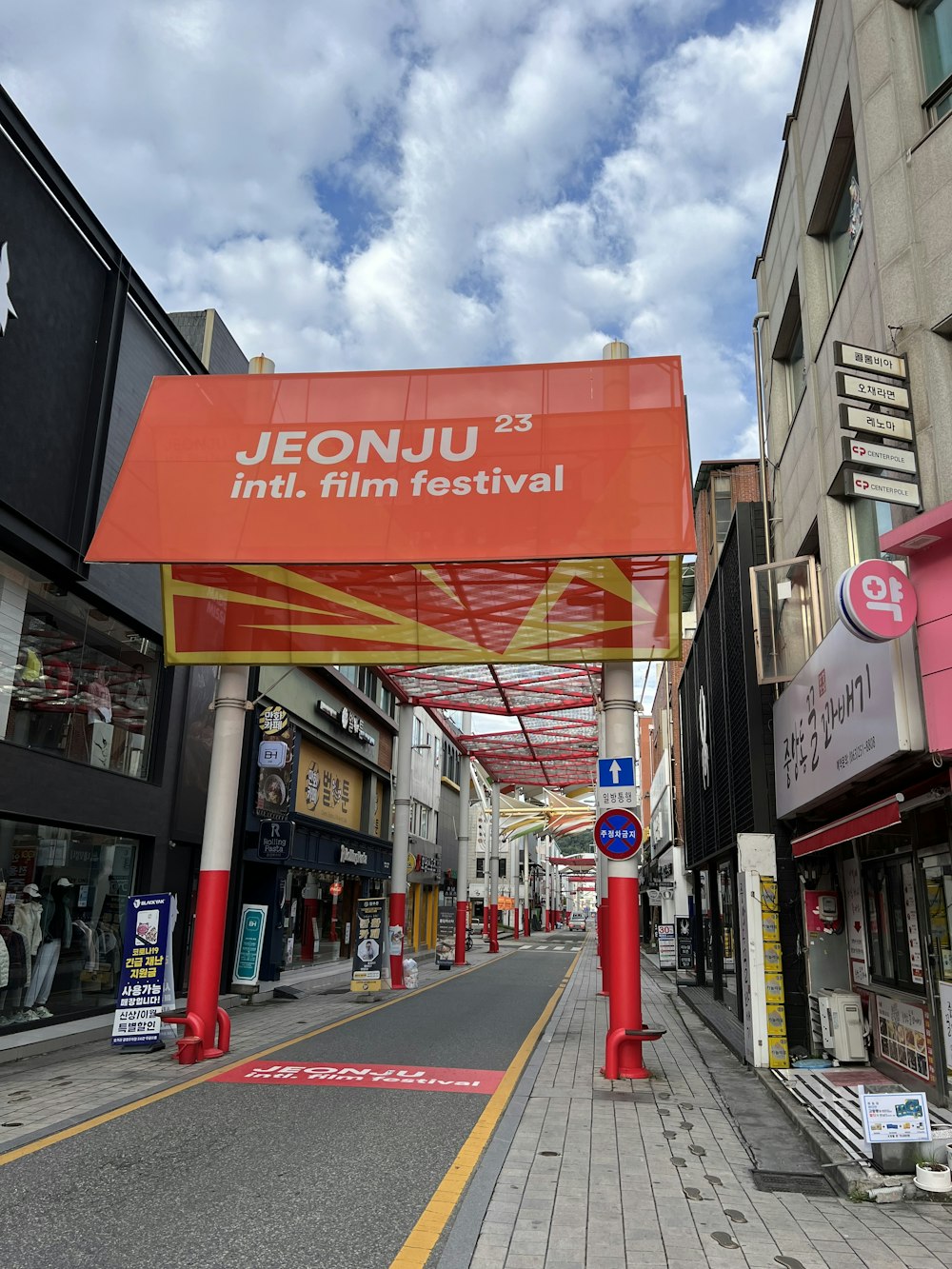 a large red sign hangs over a street