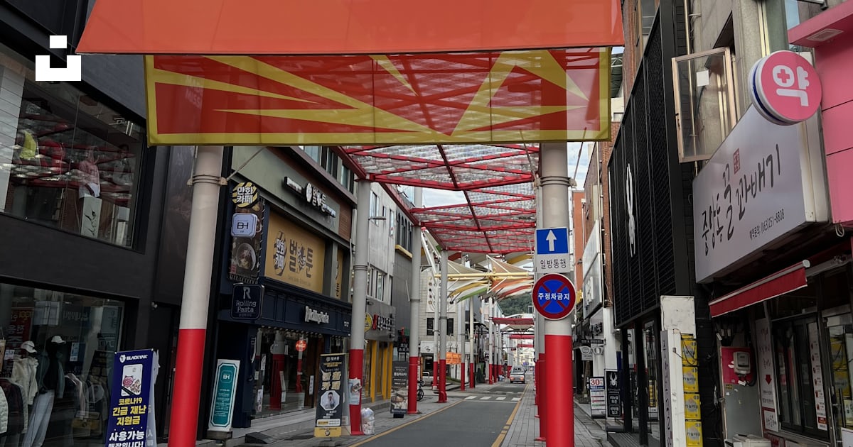 A large red sign hangs over a street photo – Free Jeonjugaeksa 5-gil ...