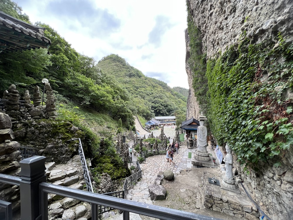 a stone wall with a stone walkway and a stone wall with a stone fence and a hill with