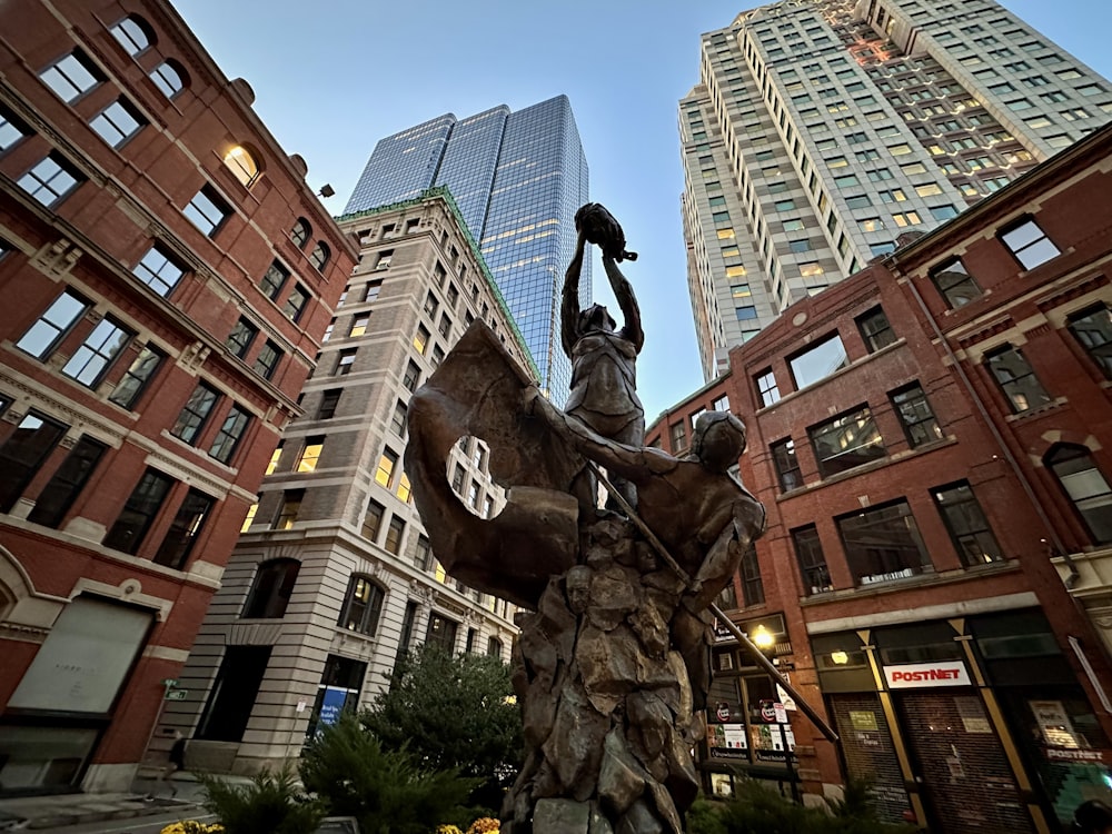 Una estatua de una persona sosteniendo una espada frente a un edificio