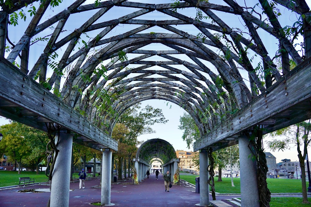 a large metal structure with people walking underneath