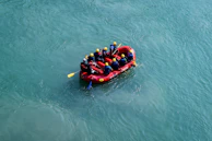Rafting guides helping participants gear up with helmets and life jackets before the adventure.