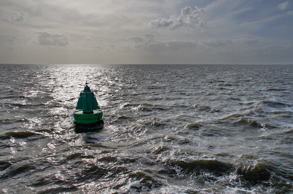 a green boat in the ocean
