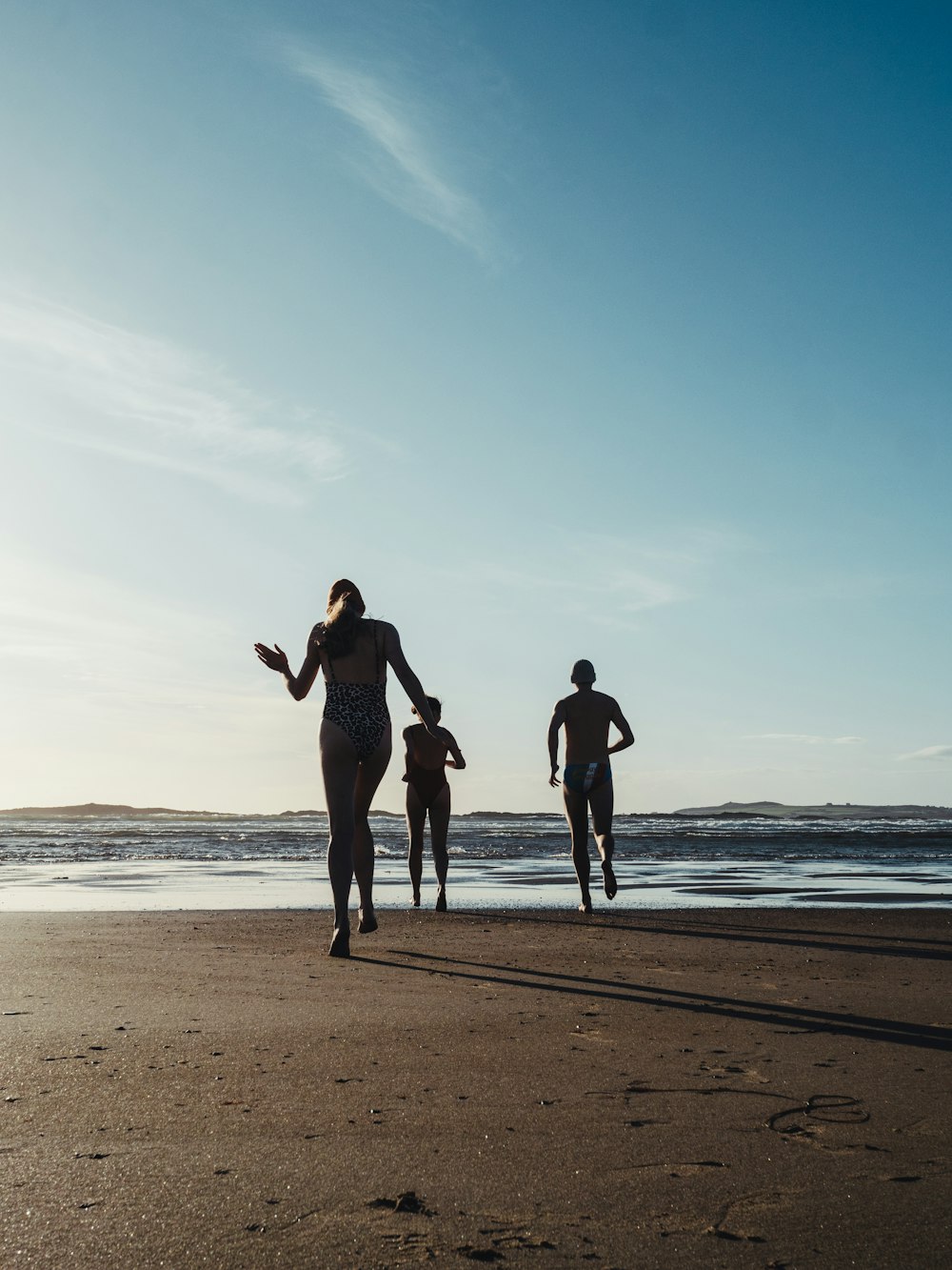 a group of people walking on a beach