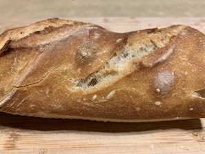 Close-up of freshly baked crusty bread with a golden-brown color on a wooden table