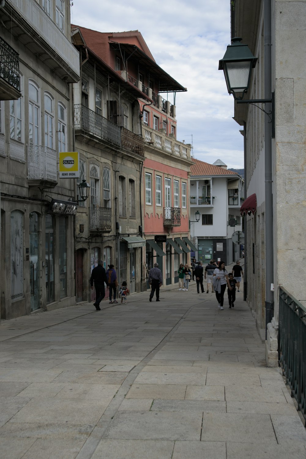 people walking on a street between buildings