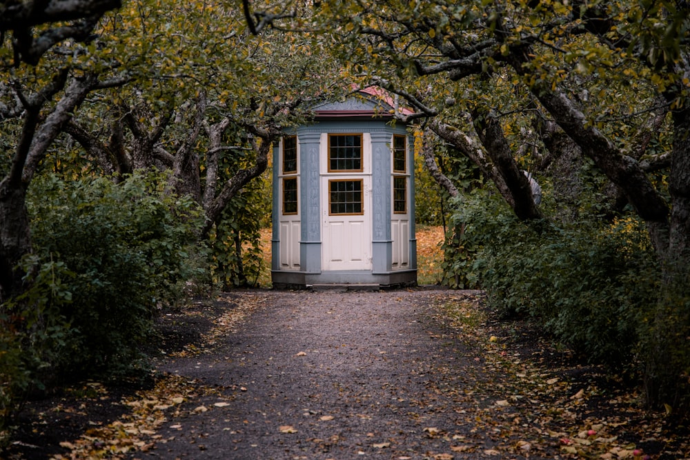 a small white building in a wooded area
