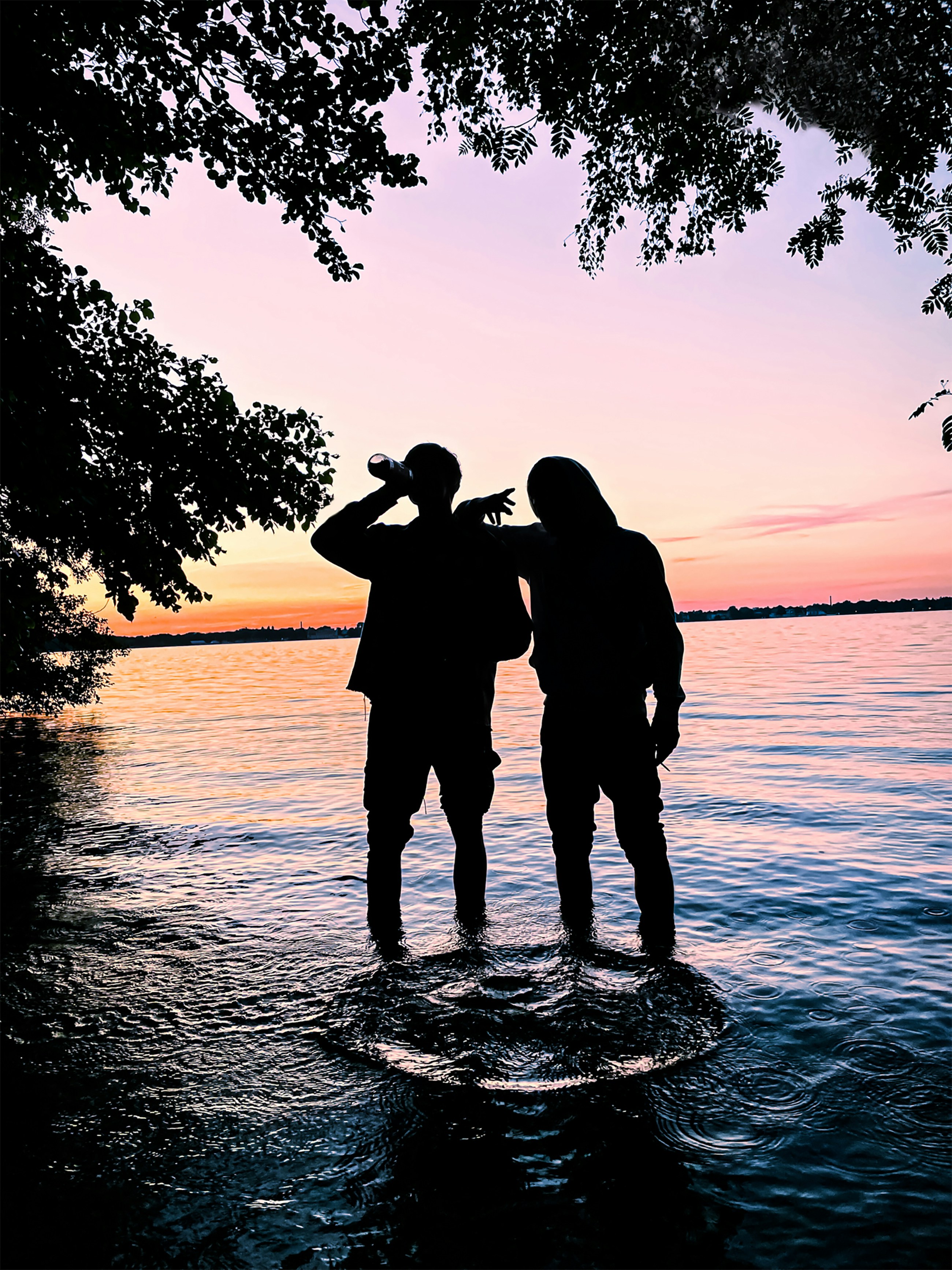 Un couple de personnes debout sur un rocher dans l’eau