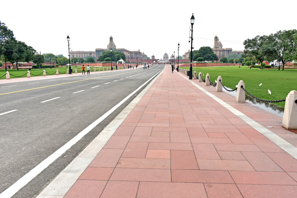 a road with a brick walkway and grass on the side