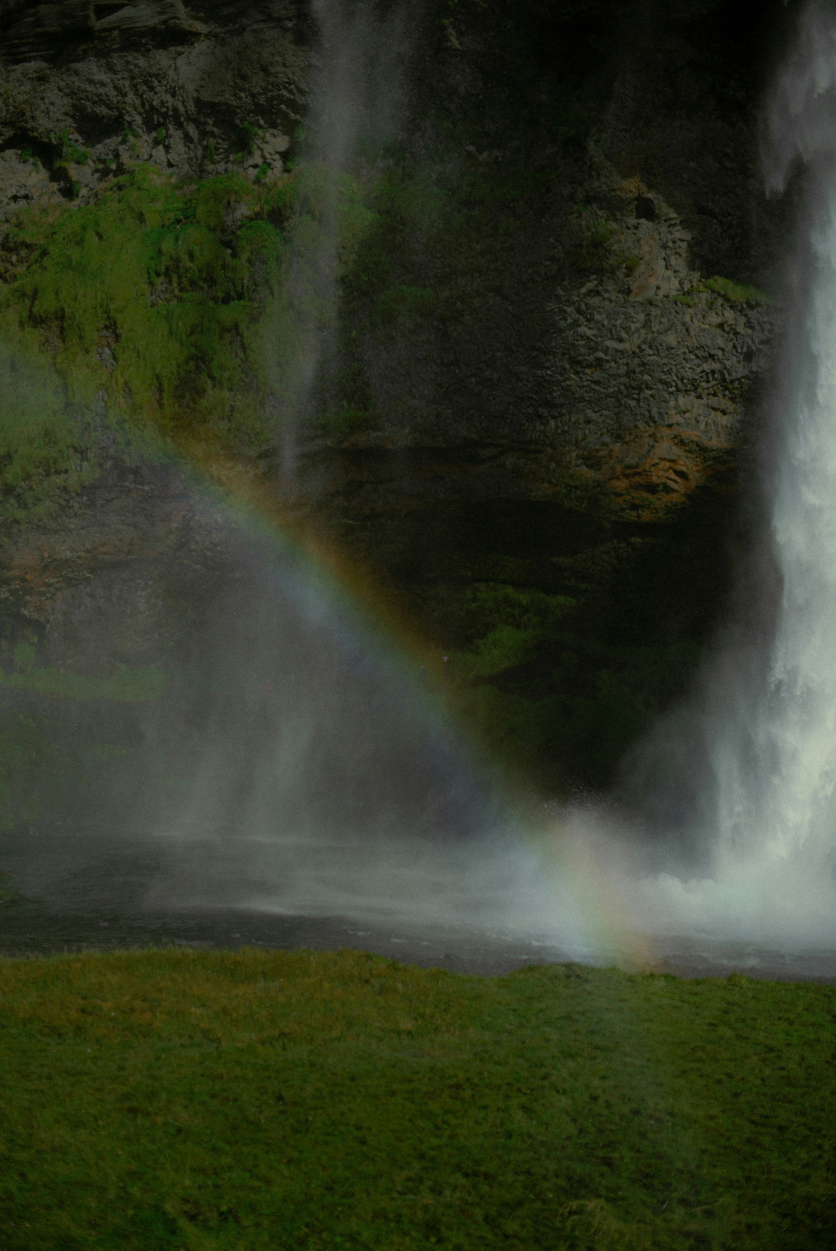 a waterfall over a grassy hill
