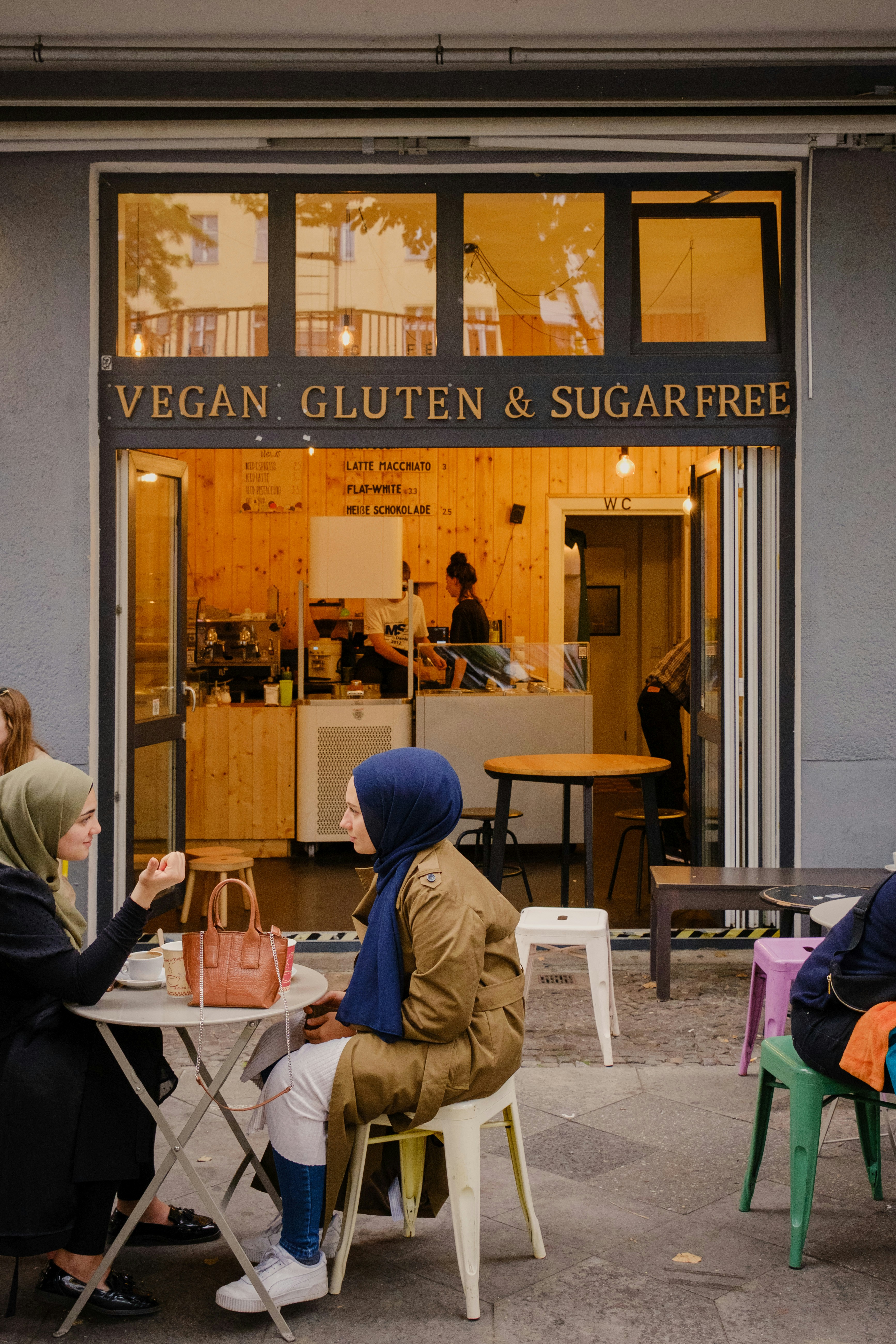a group of people sitting at a table in front of a restaurant